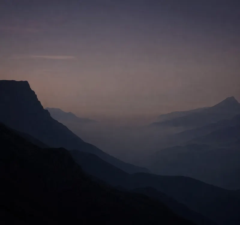 Mountain ridges fading one behind another in the mist, at daybreak