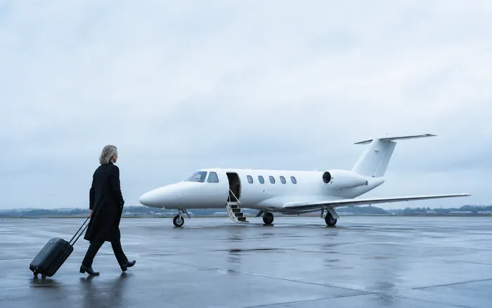A passenger walking towards a private jet on the apron