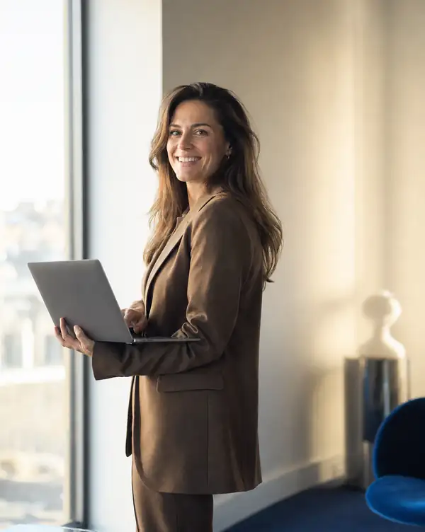 A member of staff with a laptop in the office