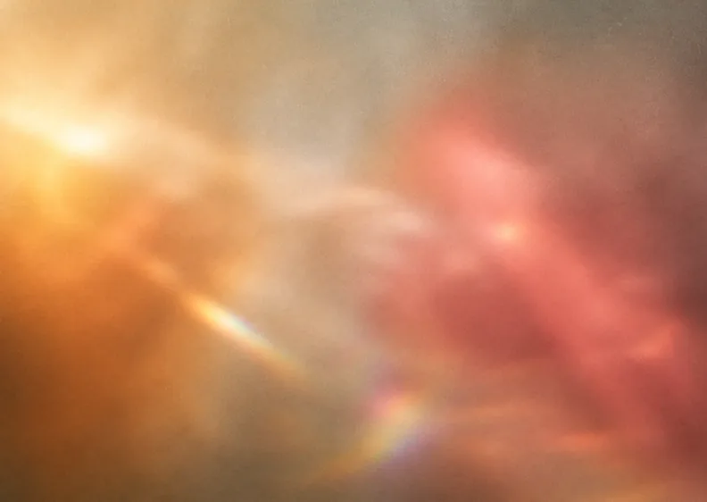 A soft bloom of iridescent light, amber bleeding into rose