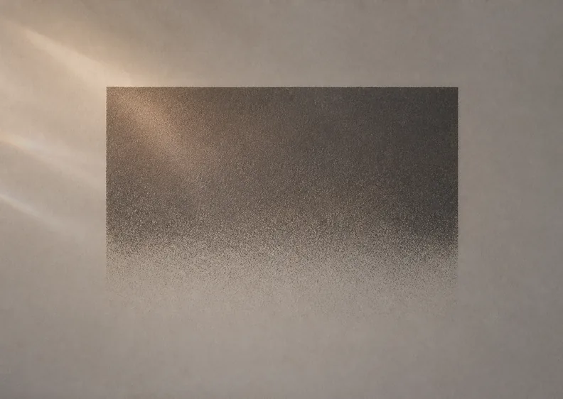 A dark grainy rectangle dissolving into fine noise at its lower edge