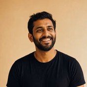 Smiling man with beard wearing a black shirt.