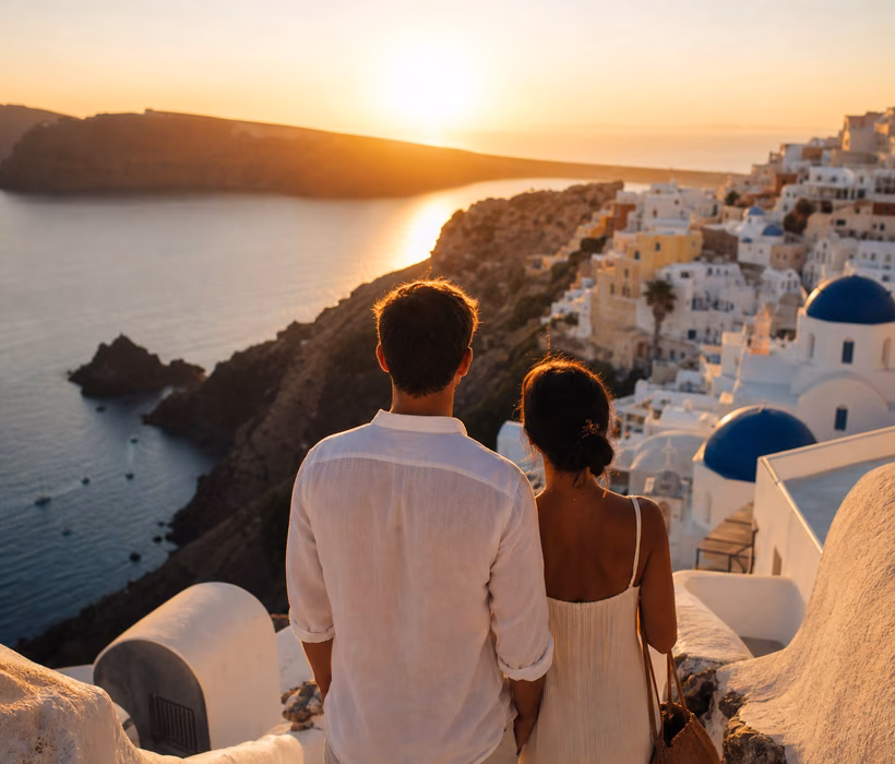 Couple watching sunset over Santorini caldera.