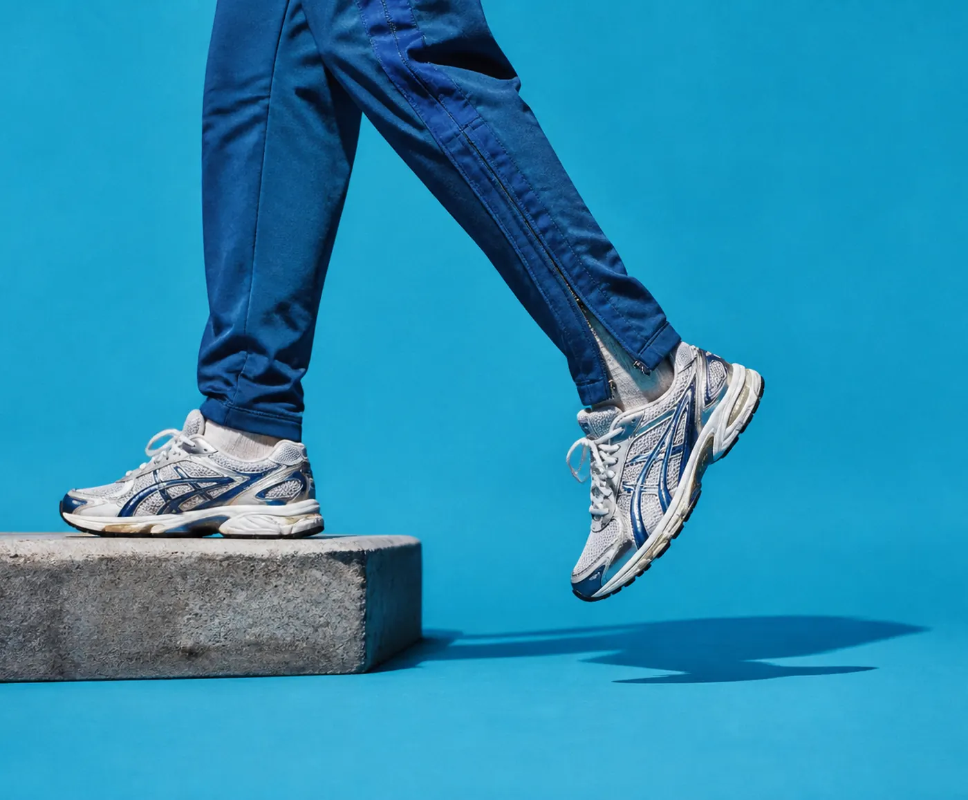 Halfstep cover: a runner in a blue tracksuit stepping off a kerb
