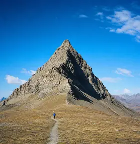 Hiker below a bare mountain ridge