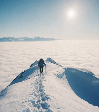 Climber on a snowy ridge above the clouds