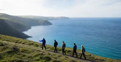 Guide leading a small group along a coastal path