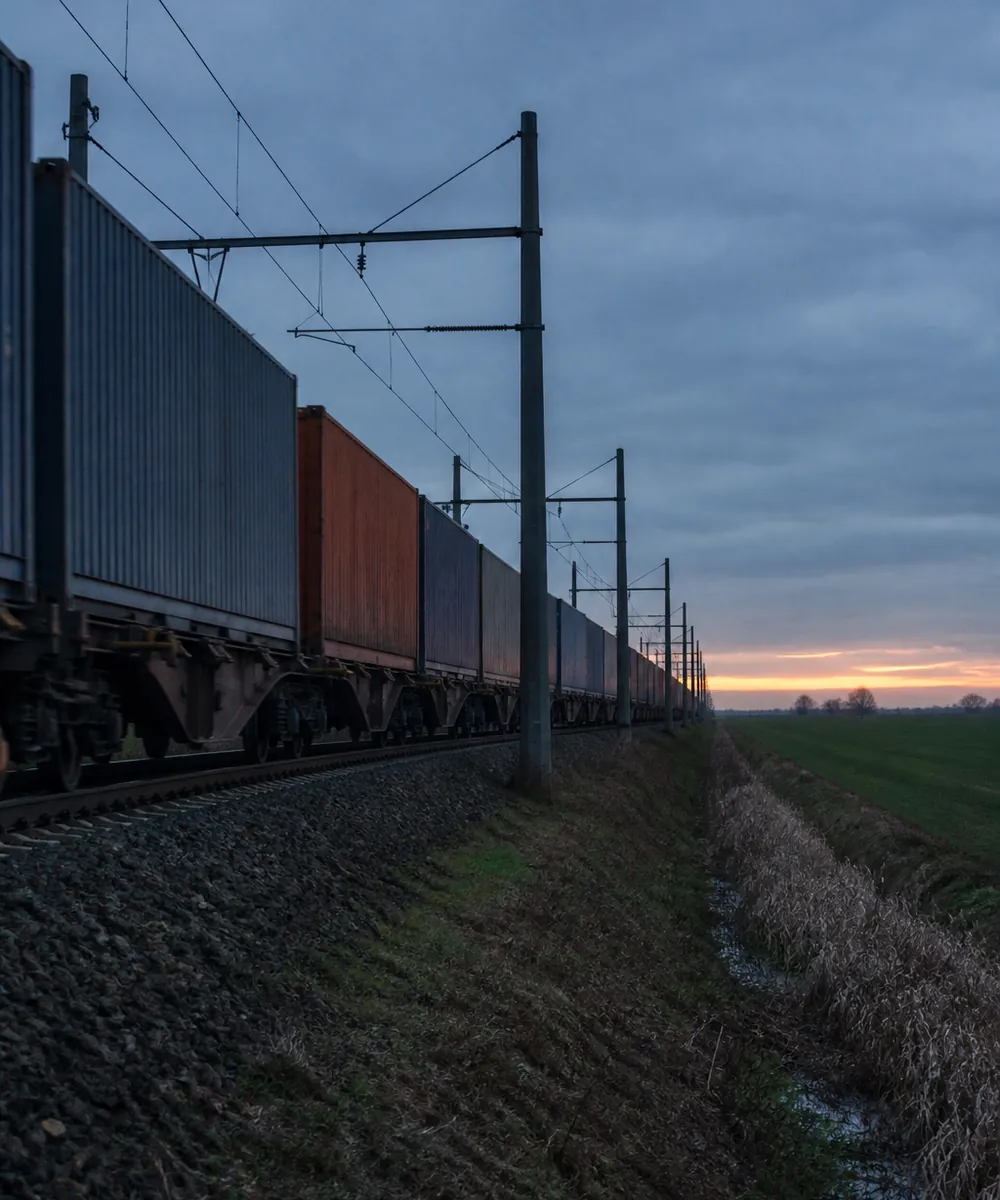 A freight train crossing open country at dusk