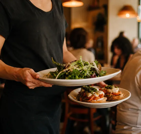 A waiter carrying two starters