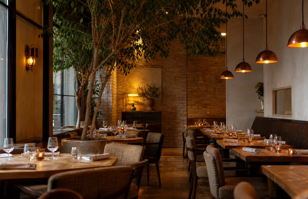 The New York dining room, long wooden tables under copper lamps